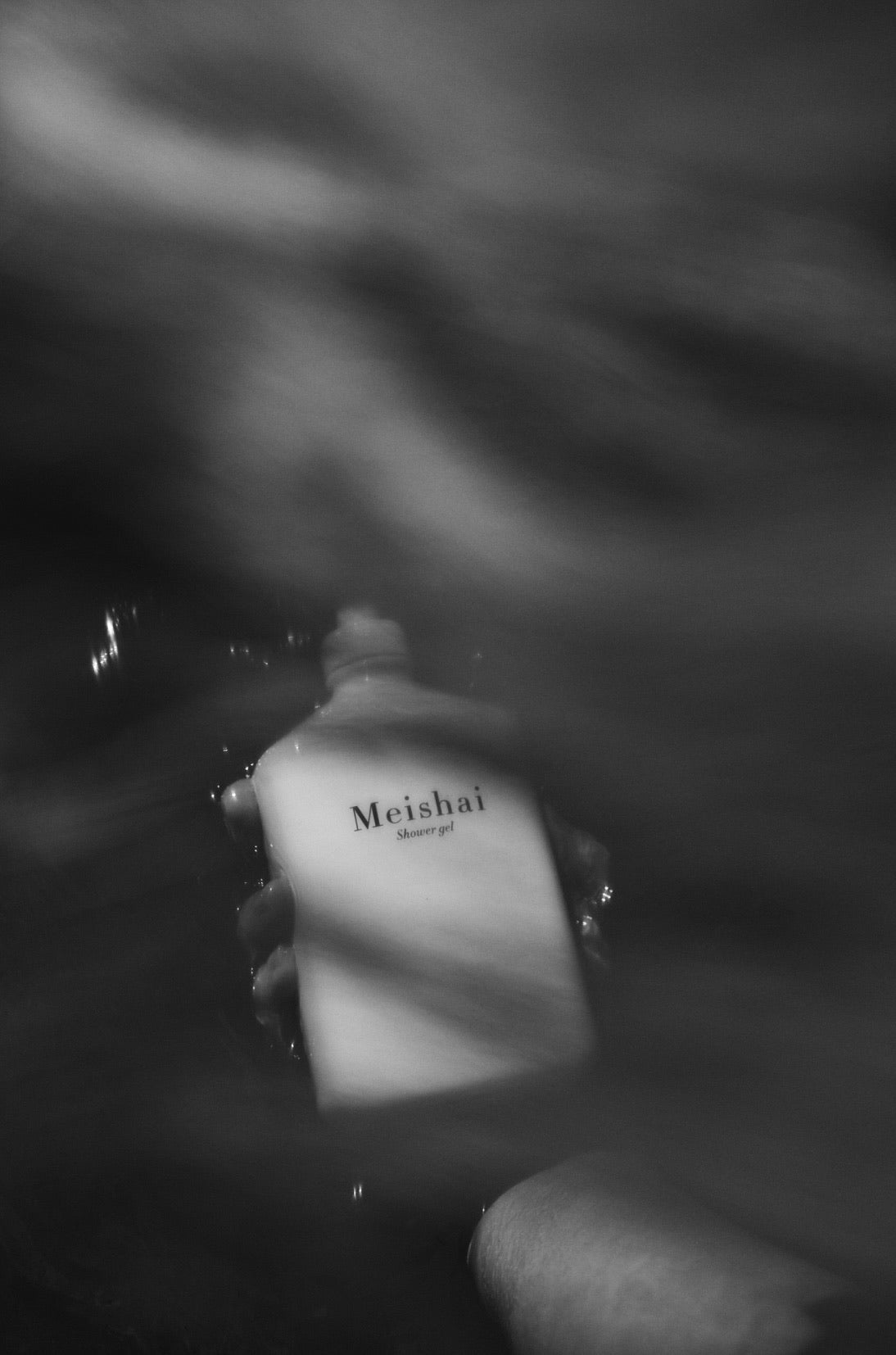 Hånd der holder Meishai Shower Gel i vand